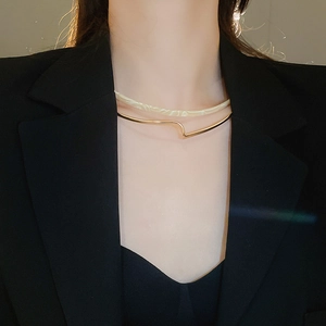Close-up of double-layer resin marble and gold wave metal choker on black blazer