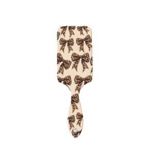 Beige air cushion hairbrush featuring leopard bow patterns and ergonomic handle