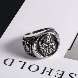 Retro gothic skull ring in vintage silver titanium steel displayed on an open book