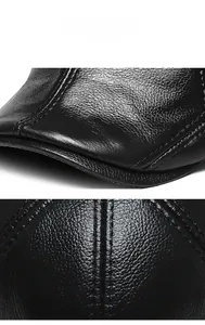 Macro detail showing the premium lychee grain texture and stitching on the black leather hat