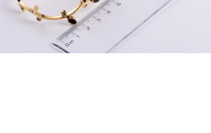 Detail of golden leaf bracelet with black enamel marquise stones and clear crystals