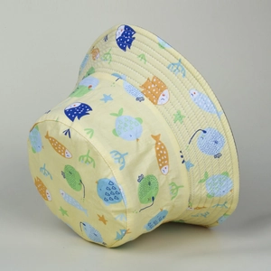 Close-up of yellow bucket hat featuring colorful cartoon sea fish and coral prints