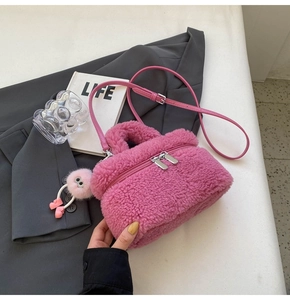 Detail of pink faux shearling mini tote bag with teddy fur texture and monster pompom charm