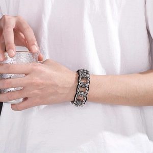 Vintage braided leather bracelet with stainless steel skull heads worn on wrist