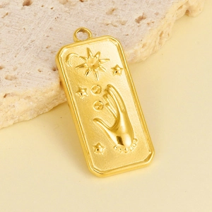 Détail macro du relief soleil et main sur pendentif rectangulaire en acier doré 18 carats
