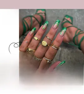 Macro view of French green-edged press-on nails with delicate floral patterns and glitter