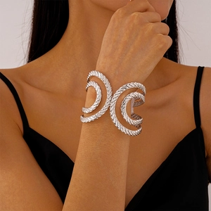 Close-up of a silver-toned open cuff bracelet with triple-layered woven texture design