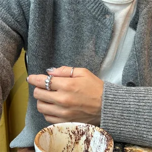 Detailed view of silver bubble ring on finger with elegant lifestyle background