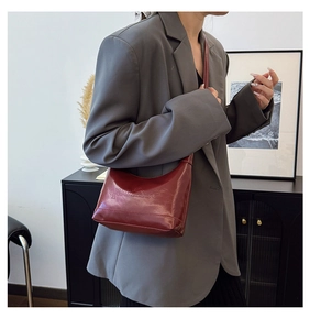 Detail of red leather shoulder bag with gaomse embossed letters on high quality texture