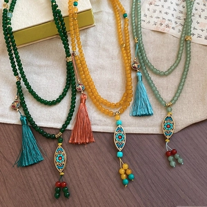 Detail of ethnic beaded necklaces featuring jade resin beads and ornate tassels