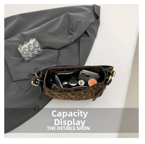 Detailed interior view of leopard print crossbody bag showing large storage capacity