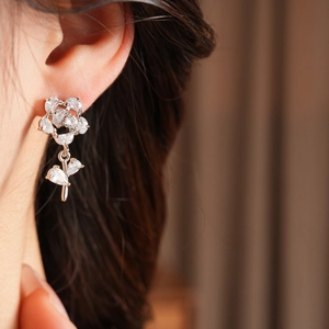 Gros plan d'une boucle d'oreille rose en argent avec zircons portée par un mannequin