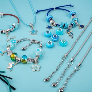 Detail of DIY bracelet set featuring blue beads, mermaid charms and silver metal chains