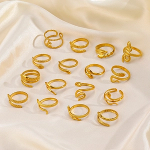 Collection of 18K gold plated stainless steel snake rings on cream silk background