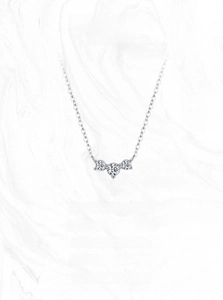 Macro shot of silver S925 geometric necklace featuring three round-cut sparkling white stones