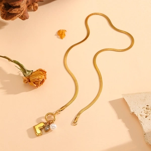 Gold flat snake chain necklace with heart charm, evil eye pendant and white pearl