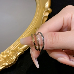 Sparkling faceted titanium steel rings in gold and silver colors worn by a model