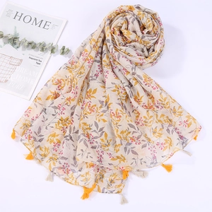 Detailed close-up of beach shawl featuring red and yellow floral patterns with small tassels