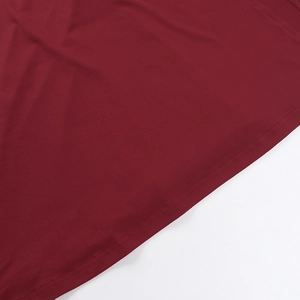 Vue macro détaillée de l'ourlet à double couture et de la texture du tissu rouge vin