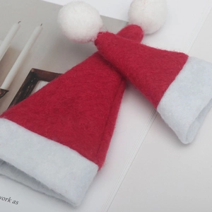 Close-up of two mini red felt Christmas hats with white trim for festive bottle decor