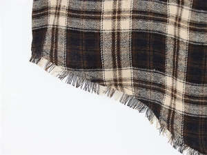 Detail of coffee and beige plaid fabric with raw fringe hem and soft flannel texture
