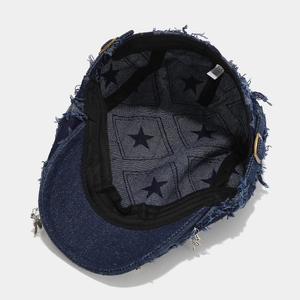 Detailed macro view of distressed denim hat with metal rings and star pattern lining
