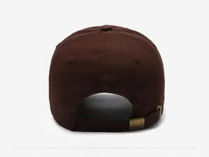 Detail of adjustable bronze metal buckle on a dark brown vintage distressed cotton baseball cap