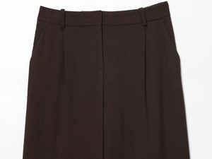 Detailed view of dark brown suit trousers featuring waist tailoring and fabric texture
