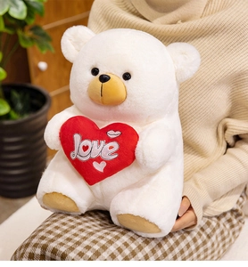 Close-up of white plush teddy bear with a red heart and 'love' embroidery details