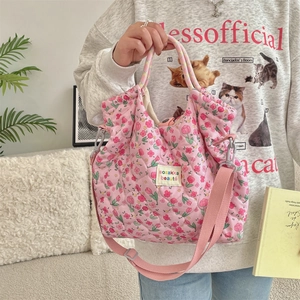 Detail of pink floral quilted tote bag with detachable strap and woven handles