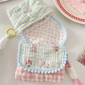 Detailed top view of a quilted cotton floral pouch with pink polka dot lining