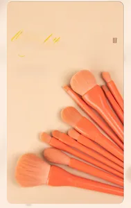Detailed view of professional candy orange makeup brush set with soft gradient bristles