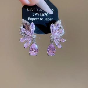 Macro detail of S925 silver butterfly earrings featuring pear-cut pink zircon crystals