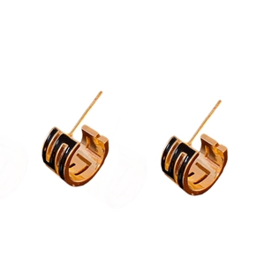 Minimalist gold-plated C-shaped earrings with black stripe accents on white background