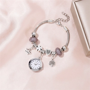 Detail of silver beaded charm watch with crown pendant and purple beads on silk