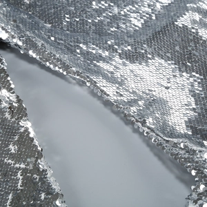 Macro shot of silver sequins fabric showing dense circular pattern and elegant drapery