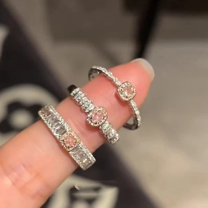 Three elegant S925 sterling silver rings featuring pink zircon stones on a model's hand