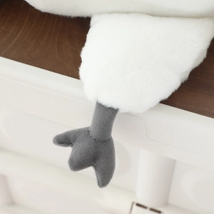 Macro shot of dark grey soft webbed feet and white faux rabbit fur on the plush pigeon toy