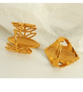 Detail of vintage bohemian open gold rings with textured stones on a stone prop