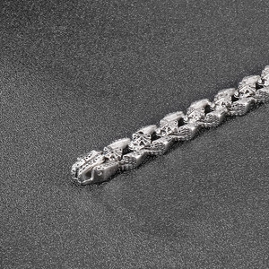 Macro shot of silver punk bracelet featuring embossed cross patterns on thick metal links