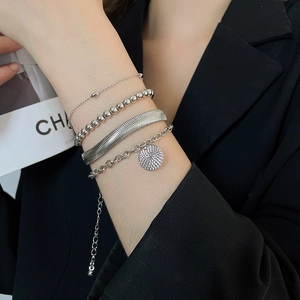 Dettaglio di un set di 4 bracciali a catena serpente d'argento con ciondoli circolari