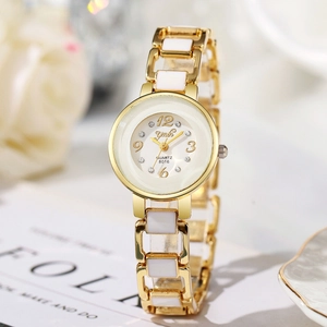 Dettaglio dell'orologio da donna dorato al quarzo con inserti in ceramica bianca e strass