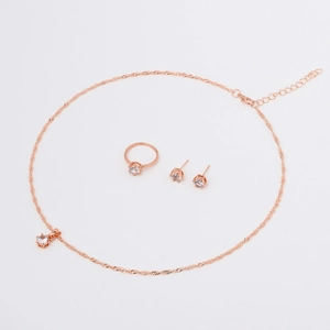 Detail view of rose gold jewelry set featuring six-prong cubic zirconia pendant and ring