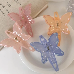 Set of four translucent butterfly hair claws in pink, orange, and blue colors