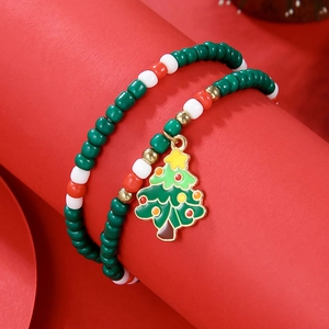 Detail of Christmas beaded bracelet with red, white, green beads and enamel tree charm