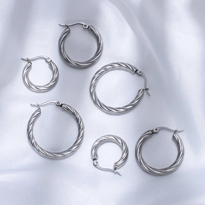 Three sizes of twisted hoop earrings in polished silver finish on white silk background