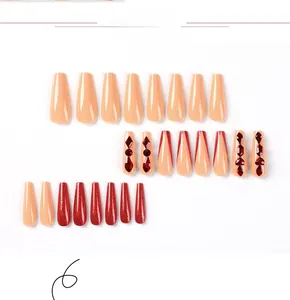 Close-up of red glitter and rhinestone long coffin press-on nails with nude french tips