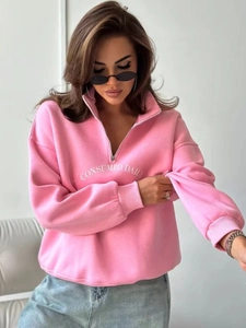 Detailansicht des rosa Sweatshirts mit halbem Reißverschluss und weißem Schriftzug