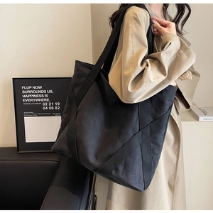 Detail of reinforced X-shape straps on charcoal canvas tote bag for daily commute
