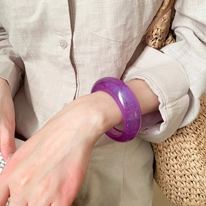 Detail of purple glitter resin bangle showing sparkling blue flakes on wide curved surface